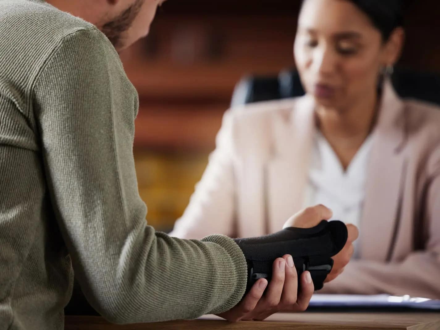 Person showing a wrist injury to an attorney during a legal consultation
