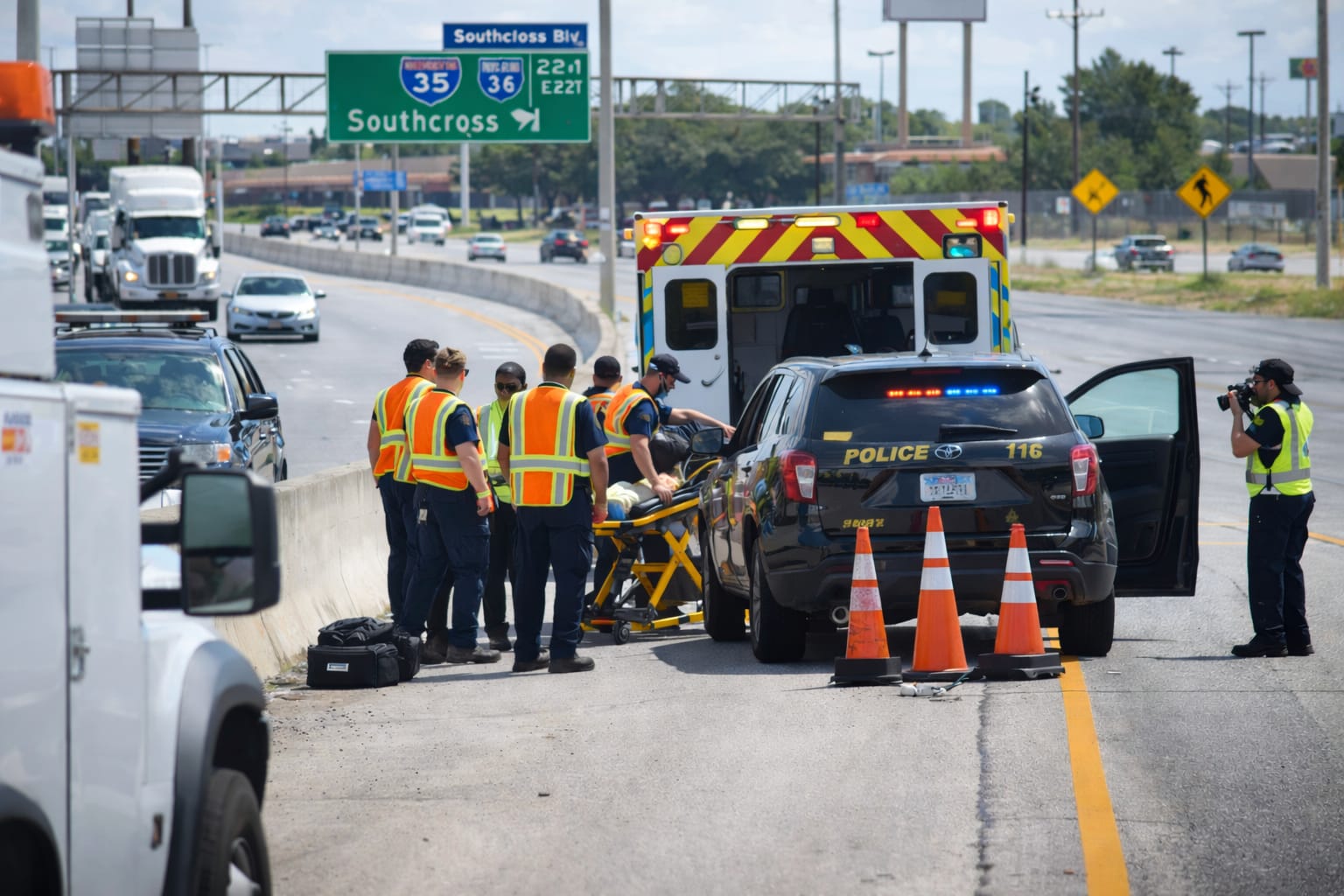 Emergency responders at the scene of a road accident with vehicles and traffic cones