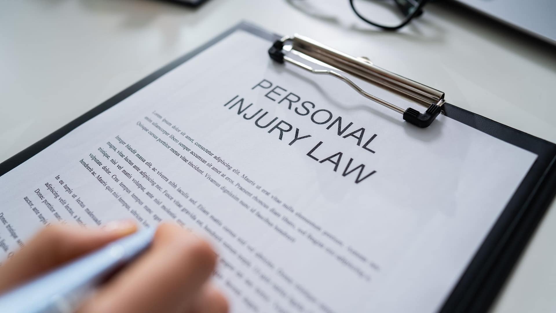 Person reviewing a personal injury law document on a clipboard