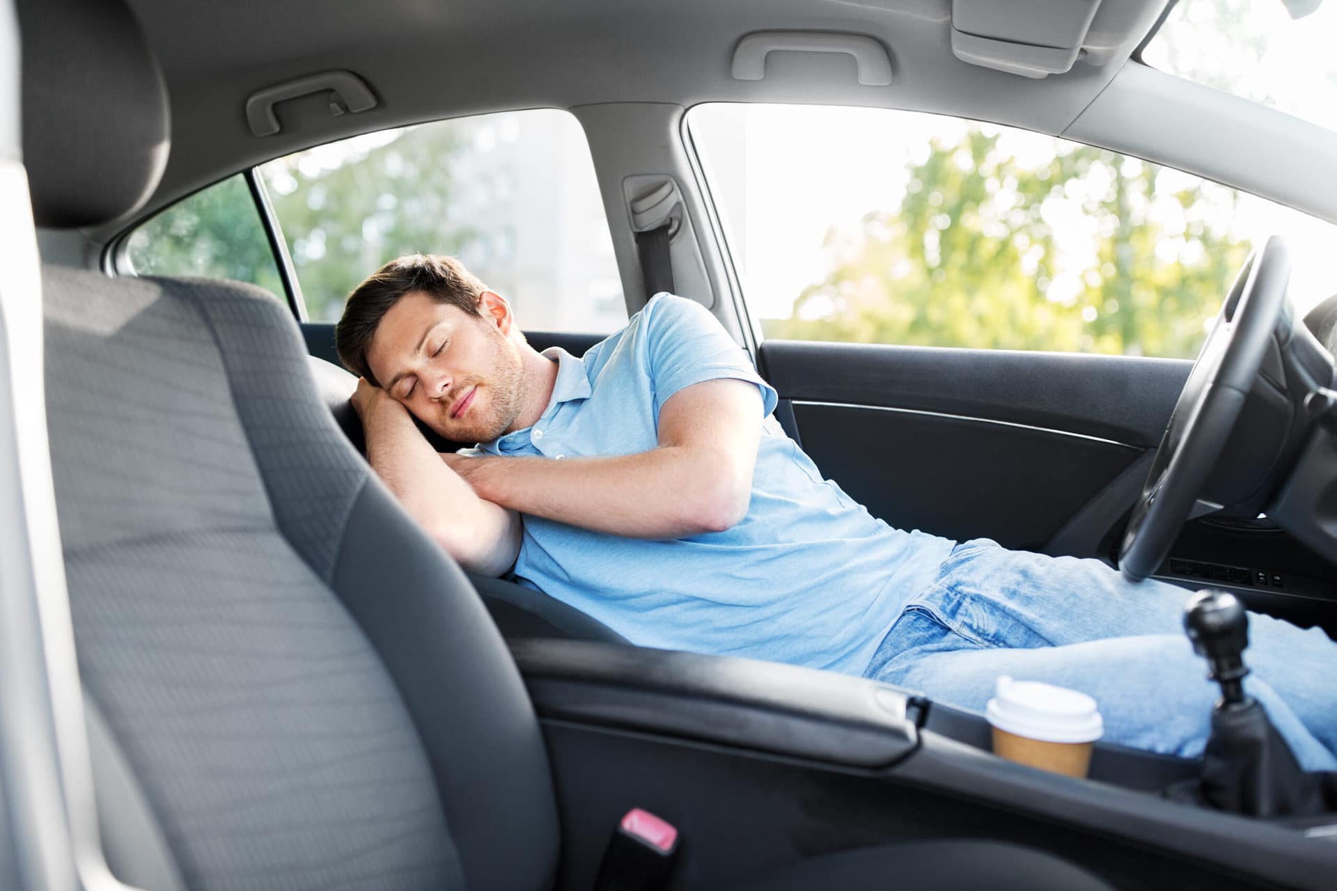 transport, rest and driving concept - tired man or driver sleeping in car