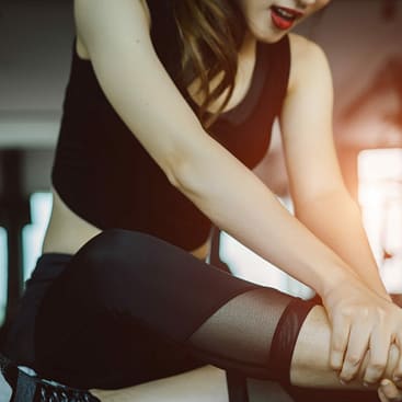 ¿Puedes demandar a un gimnasio por lesiones causadas por equipos defectuosos? 2 Mujer sujetándose el tobillo después de una lesión en un gimnasio.