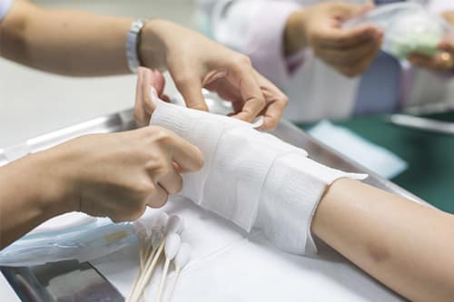Medical professional bandaging a patient's hand and wrist after an injury