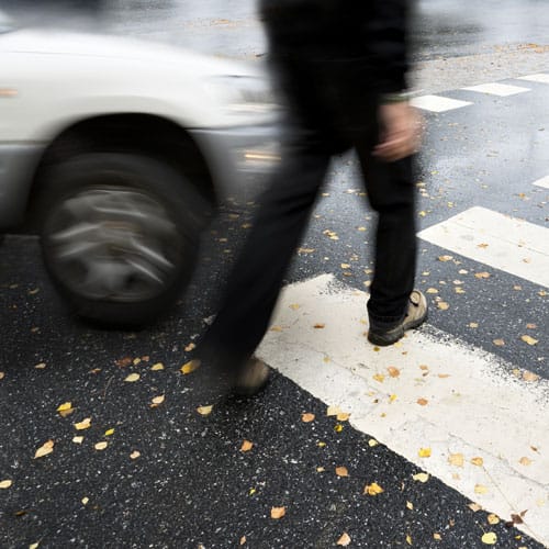Pedestrian crossing busy Atlanta street near moving traffic