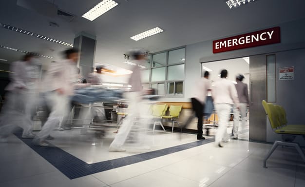 A motion blurred photograph of a patient on stretcher or gurney being pushed at speed through a hospital corridor. New coronavirus (novel Coronavirus 2019 disease, COVID-19, nCoV).
