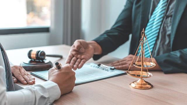 man signing a contract with a lawyer - Glendale Wrongful Death Lawyers