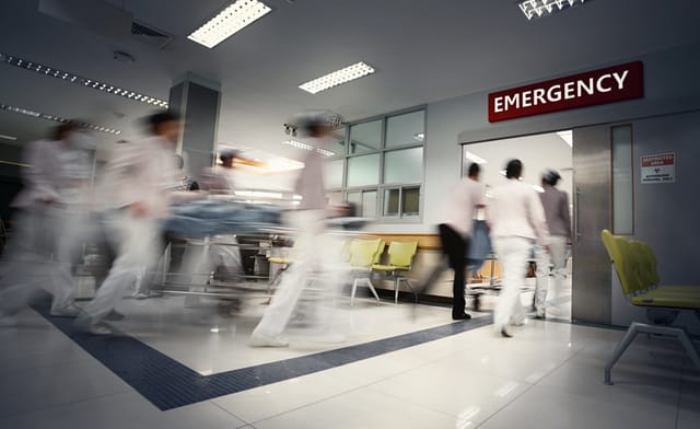 A motion blurred photograph of a patient on stretcher or gurney being pushed at speed through a hospital corridor. New coronavirus (novel Coronavirus 2019 disease, COVID-19, nCoV).