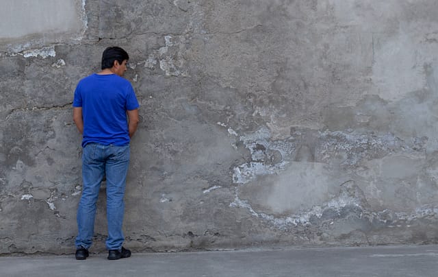 general shot of a man with jean who is urinating on the street. Is Peeing in Public Illegal in Texas?