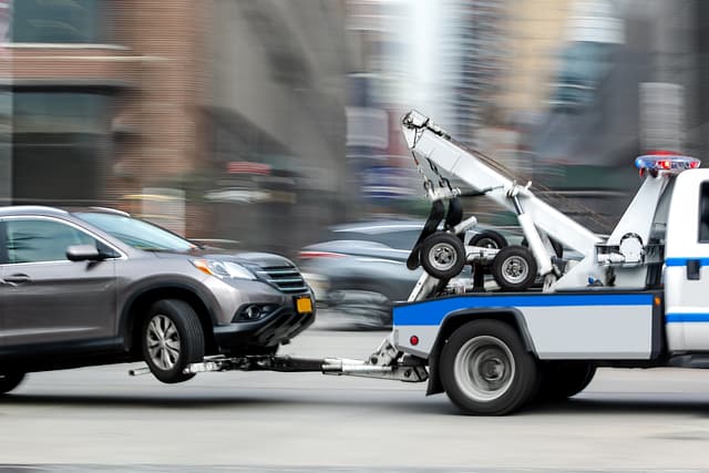 Tow truck delivers the damaged vehicle as it is towed away