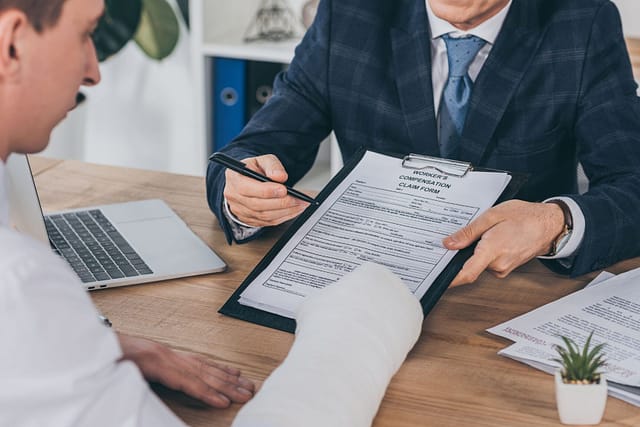 man signing damages claim form with a lawyer - Scottsdale Personal Injury Lawyers