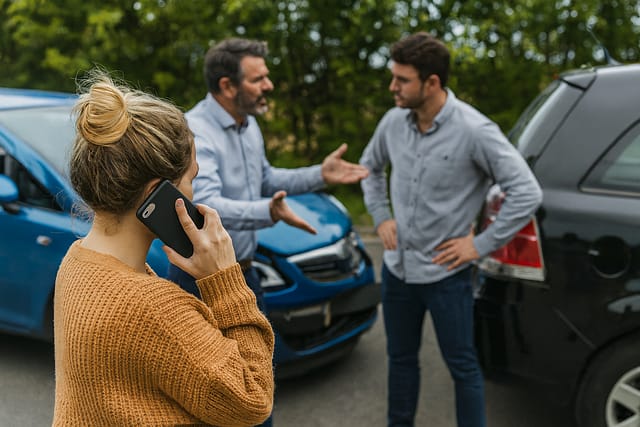 How Is Fault Determined in a Car Accident in Arizona? 3 Drivers arguing after a car accident, illustrating a 50/50 insurance claim