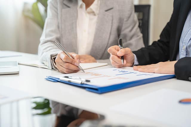 Personal injury lawyer reviewing financial damages and settlement documents with a client