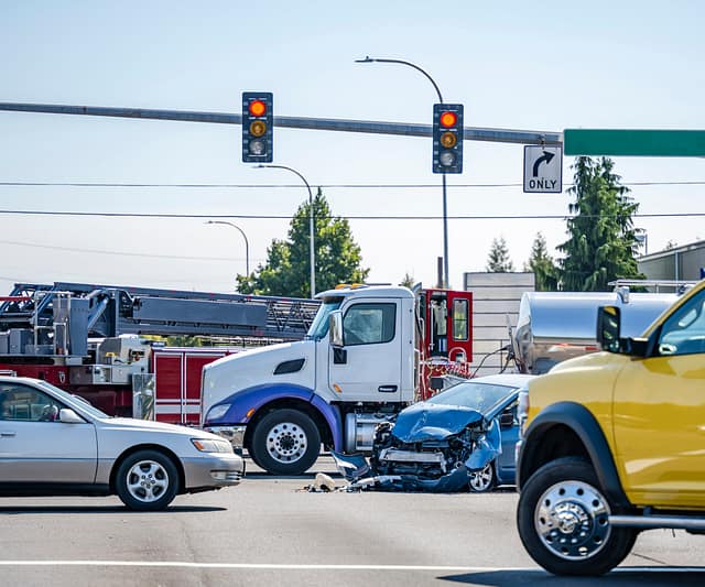 Intersection accident involving a car and a big rig semi truck w.