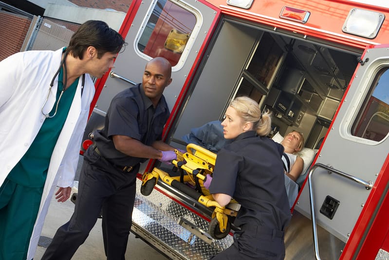 Paramedics and doctor unloading patient from ambulance. Medical Care
