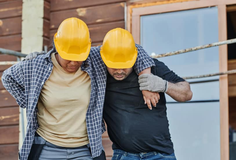 Construction worker helping another worker after an accident - Mesa Personal Injury Lawyers